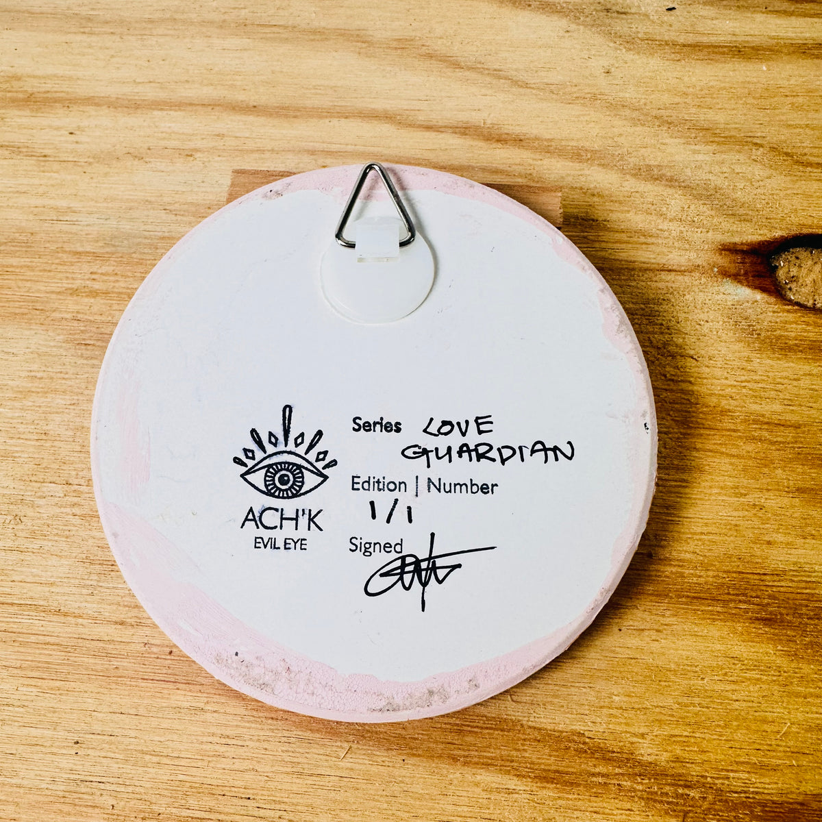 Achk pink evil eye wall art by Melbourne artist Ani Ipradjian, a hand-painted ceramic amulet inspired by heart healing and protection from toxic connections.