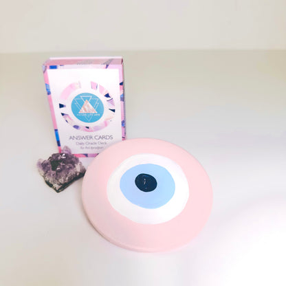 Collectible pink ceramic evil eye amulet by Ani Ipradjian, an Achk spiritual protection wall hanging symbolising compassion, love and emotional wellbeing.