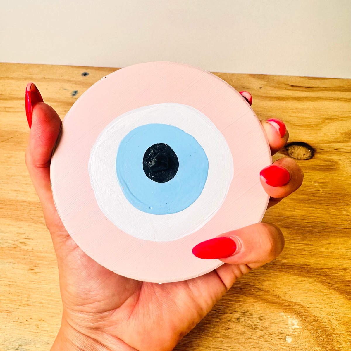 Love Guardian pink ceramic evil eye by Ani Ipradjian, an Achk spiritual wall hanging representing true love, self-worth and protection against jealousy.